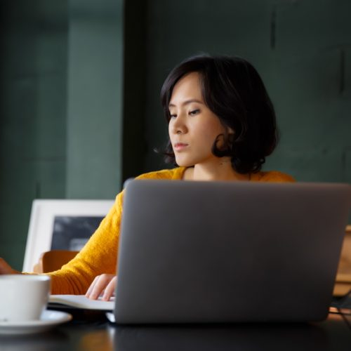 young-business-woman-in-yellow-dress-sitting-at-table-in-cafe-and-writing-in-notebook-student_t20_9lPGJN