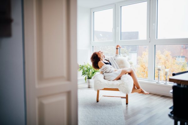 young-women-sitting-on-chair-at-home-in-living-room_t20_QQvV9G